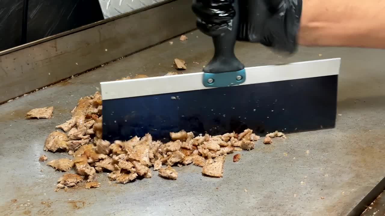 Meat being chopped on the grill